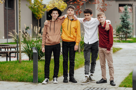 Group of smiling and happy teenage friends wearing casual clothes spending time together, posing and...
