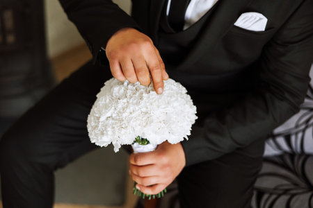 Stylish portrait of the groom with a bouquet of flowers. A man is preparing for a wedding ceremony...