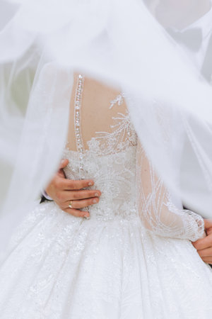 The groom hugs the bride from behind, the bride holds a wedding bouquet. Cropped photo. Groom in a...