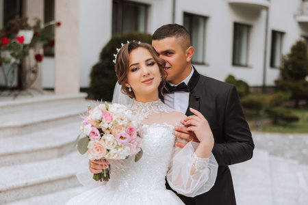 Wedding. Love and couple in garden for wedding. Celebrating the ceremony and commitment. Save the date. Trust. The groom gently hugs the bride by the shoulders. Couple in love. Wedding portraitの写真素材