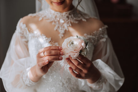 wedding boutonniere of flowers in the hands of the bride. Wedding details. The first meeting of the bride and groom. The bride is waiting for the groom.の写真素材