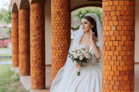 Beautiful bride with wedding flowers bouquet, attractive woman in wedding dress. Happy newlywed woman. Bride with wedding makeup and hairstyle. Smiling bride. Wedding day. Gorgeous bride. Marriage.の写真素材