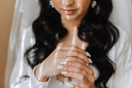Hands of the bride in a white wedding dress with a gold wedding ring with a diamond close-up. Wedding photoの写真素材