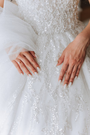 close-up of female hands touching dress. Women's manicure. A luxurious wedding ring on a woman's finger.の写真素材
