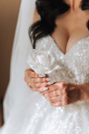 wedding boutonniere of flowers in the hands of the bride. Wedding details. The first meeting of the bride and groom. The bride is waiting for the groom.の写真素材