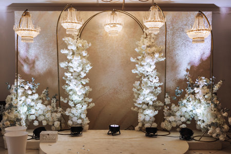 The photo zone at a wedding or birthday celebration is decorated with flowers and illuminated by artificial lightの写真素材