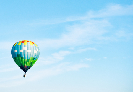 A balloon against a blue cloudy sky