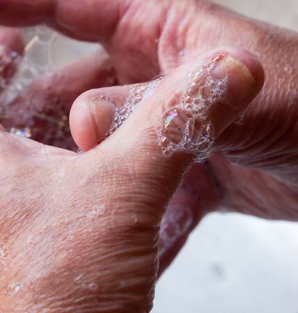 Wash hands, a man washes his hands under the tap with soap and water. A man rinsing his hands under...
