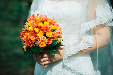 Bride with a bouquet of orange flowers. Wedding bouquet.の写真素材