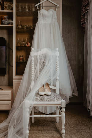 Wedding dress, white shoes on the chair. The bride's clothes.の写真素材
