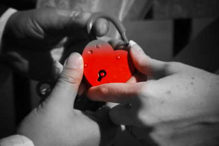 The newlyweds hold a red lock in their hand. Wedding.の写真素材