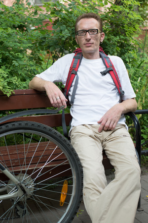 Man with bicycle rest on the benchの写真素材