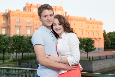 young pretty couple smiling and hugging outdoor in the historical city center near palaceの写真素材