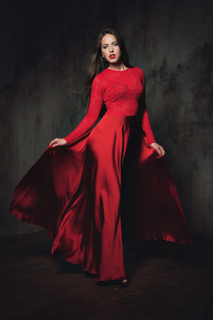 Sexy young lady in fluttering red dress and long hairの写真素材