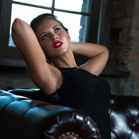 Sexy young lady in black lace dress, loft interiorの写真素材