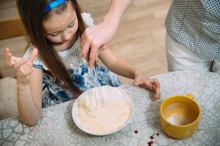 little  mothers helper. Small girl going to beat the dough for pancakesの写真素材