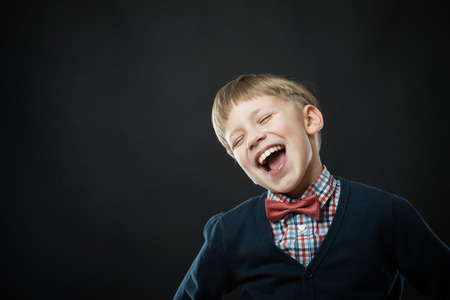 Close up portrait of young smiling cute boy in blackの写真素材