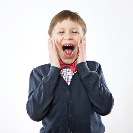 Boy shouting loudly. studio shot, white の写真素材