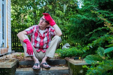 tired worker sitting on the doorsteps after hard workの写真素材