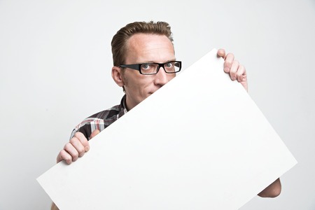 man in eyeglasses peep from the white board. .の写真素材