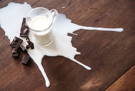 Chocolate and spilled milk on the table.Top view. Eco life concept.の写真素材