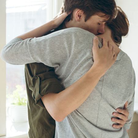 young man embrace tenderly his girl. close up detail.の写真素材