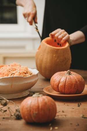woman hands curving pumpkin preparing for Halloweenの写真素材