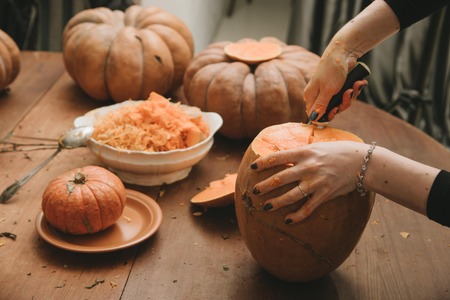 woman hands curving pumpkin preparing for Halloweenの写真素材