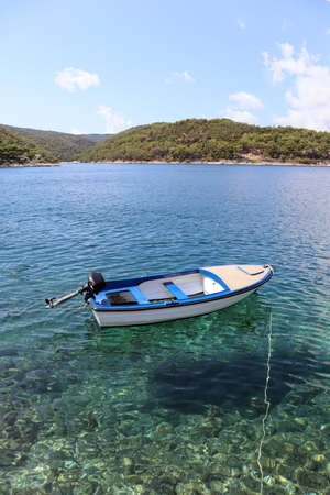 Seascape boat and sea, mountains with pine trees on the horizon on a summer sunny day, Adriatic coast, island of Brac, Croatiaの写真素材