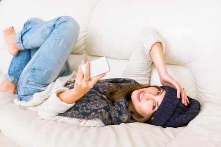 Cute girl in hat with phoneの写真素材