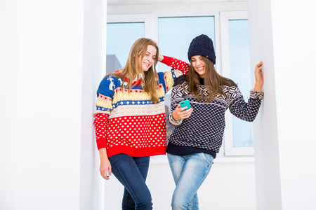 Two beautiful girls with a mobile phoneの写真素材