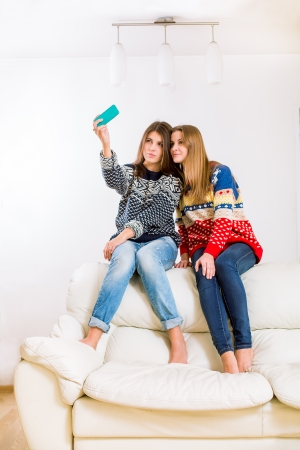 Two beautiful girls with a mobile phoneの写真素材