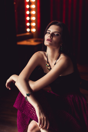 indoor shot of young brunette model posing in fashionable clothes in burlesque fitting roomの写真素材