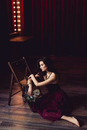 young brunette model woman posing in fashionable clothes in burlesque fitting roomの写真素材
