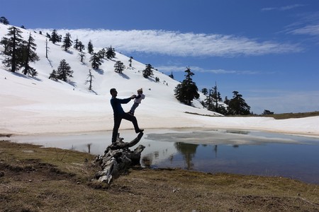 A father plays with his daughter in front of an alpine lake in Greece.の写真素材