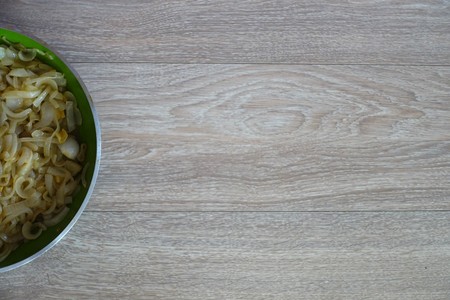 Caramelized onions A frying pan with caramelized onions on a wooden table.の写真素材