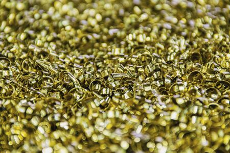 Industrial waste in the form of yellow metal chips, sharp abrasive debris.