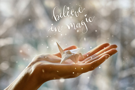 Fabulous paper crane in the palm of your hand. Believe in magicの写真素材