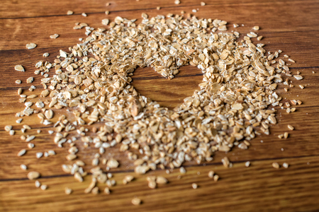 Heart painted in oatmeal on wooden background. Healthy food conceptの写真素材