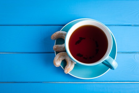 Cup of tea and biscuits on a background of a brick wall.