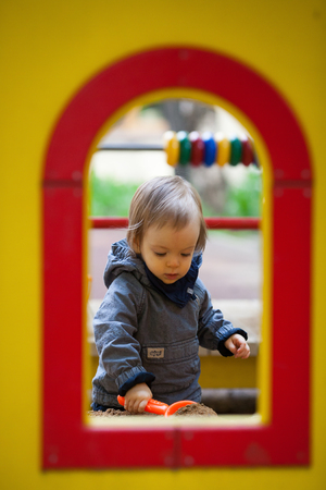 Small boy playing outside. Portrait of 2 year old toddler with blond hair and blue eyes.の写真素材