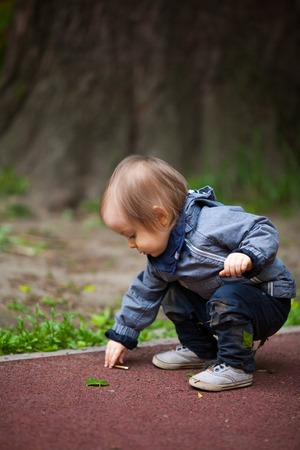 Small boy playing outside. Portrait of 2 year old toddler with blond hair and blue eyes.の写真素材
