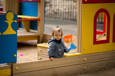 Small boy playing outside. Portrait of 2 year old toddler with blond hair and blue eyes.の写真素材