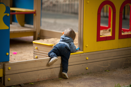 Small boy playing outside. Portrait of 2 year old toddler with blond hair and blue eyes.の写真素材