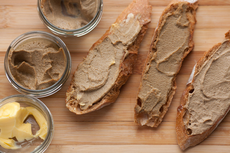 Bread with veal and rabbit pate with butter on a bamboo board. Top viewの写真素材
