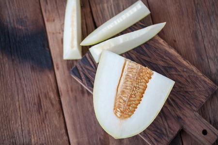 Fresh pieces of melon on the wooden background. top view with copy space.の写真素材