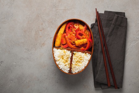 Wooden lunch boxe with healthy food ready to go for work or school, ahead meal preparation or dieting concept. On a old stone table with rust. Top view with copy space.の写真素材