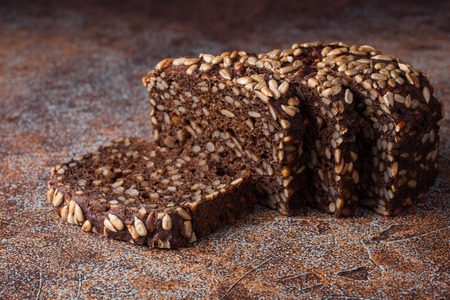 Fresh black bread with sunflower seeds on an old rusty table.