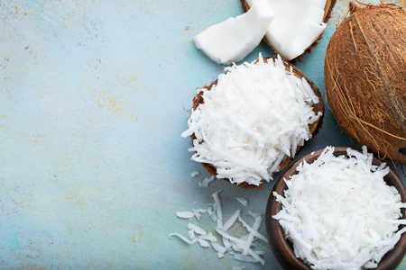 Coconut flakes in a shell on a blue background. top view with copy spaceの写真素材