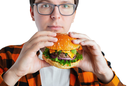 A young guy with glasses holding a burger.の写真素材